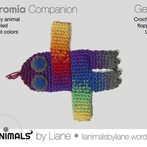 May include: A crocheted rainbow-colored toy animal with large blue eyes. The toy is called a "Chromia Companion" and is part of a line of crocheted toys called "Geonimals".