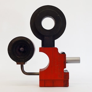 May include: A red wooden tool with a black metal ring and a black metal cylinder with a small hole in the center. The tool has the text "WESTFIELD TOOL CO.  MADE IN U.S.A.  2"