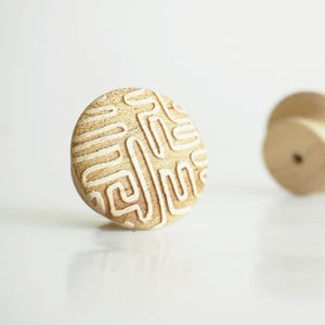 Op de afbeelding: Een set van drie keramische mokken met een gespikkelde, matte afwerking. De mokken zijn in crème, lichtbruin en donkerbruin. Elke mok heeft een eenvoudig, minimalistisch ontwerp.