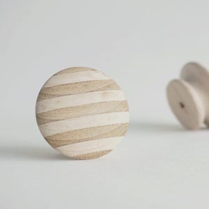 Op de afbeelding: Een set van drie keramische mokken met een gespikkelde, matte afwerking. De mokken zijn in de kleuren crème, lichtgrijs en donkergrijs. Elke mok heeft een eenvoudig, minimalistisch ontwerp, perfect voor koffie of thee.