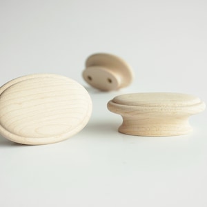 Peut inclure: Trois boutons en bois de différentes formes et tailles. Les boutons sont non finis et ont une couleur bois naturelle.