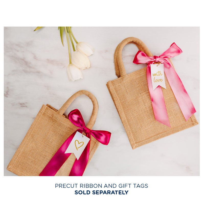 May include: Two small burlap tote bags with pink ribbon bows and gift tags. One tag says "with love" and the other has a heart.