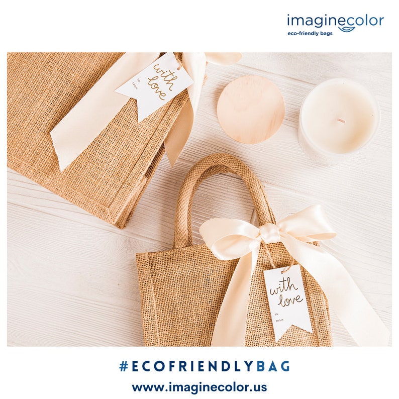 May include: Two brown burlap tote bags with white tags that say "with love" on a white wooden surface. The bags are tied with a beige ribbon and one bag has a small wooden coaster next to it.  #ECOFRIENDLYBAG www.imaginecolor.us