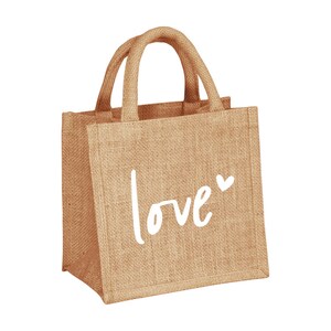 Pu&ograve; includere: Una piccola borsa di juta marrone con la scritta "love" in bianco e un piccolo simbolo di cuore.