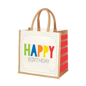 May include: A brown jute tote bag with red and white stripes. The bag has a white panel with the text "HAPPY BIRTHDAY" in colorful letters.
