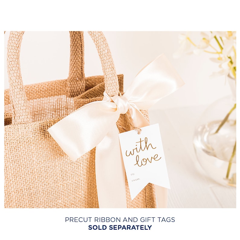 May include: A brown burlap gift bag with a white satin ribbon tied around the handles. A white gift tag with gold lettering reads "with love".