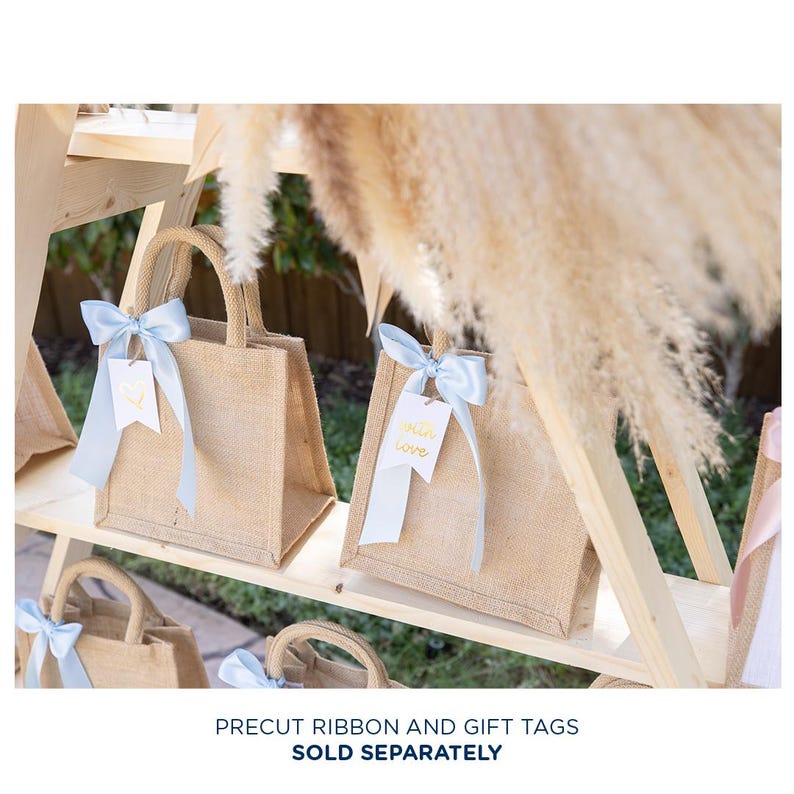 May include: A wooden shelf display with small burlap bags decorated with blue ribbon and gold gift tags. The tags read "with love".
