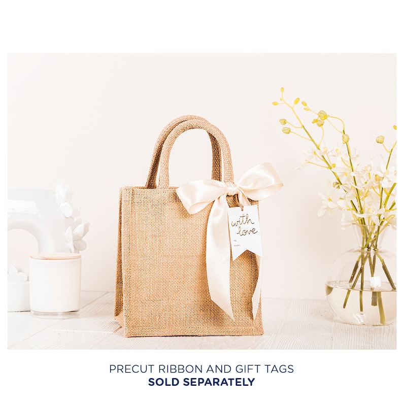 May include: A small, brown burlap tote bag with a white satin ribbon bow and a white gift tag that says "with love".