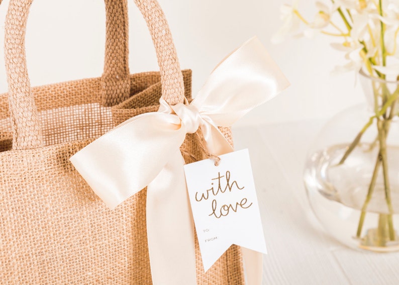 May include: A burlap tote bag with a white satin ribbon and a gift tag that says "with love".