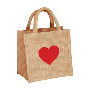 Pu&ograve; includere: Una piccola borsa di juta marrone con un design a forma di cuore rosso. La borsa ha due manici ed &egrave; realizzata in fibre naturali.