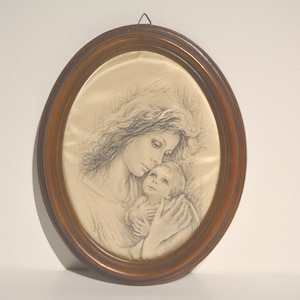 Könnte beinhalten: Ein oval gerahmtes Bild einer Mutter und eines Kindes. Die Mutter hält das Kind fest an sich und beide schauen sich an. Die Zeichnung ist in Schwarzweiß und auf einem cremefarbenen Hintergrund.