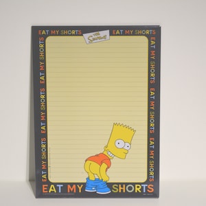 Peut inclure: Un bloc-notes jaune avec du papier ligné et une bordure noire. La bordure comporte le texte "Eat My Shorts" répété plusieurs fois dans différentes couleurs. Le bloc-notes présente une image de dessin animé de Bart Simpson des Simpsons, avec le texte "Eat My Shorts" en bas.