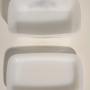 Może przedstawiać: Dwa białe prostokątne ceramiczne naczynia z lekko zaokrąglonymi krawędziami. Naczynia są puste i wyglądają na część zestawu.
