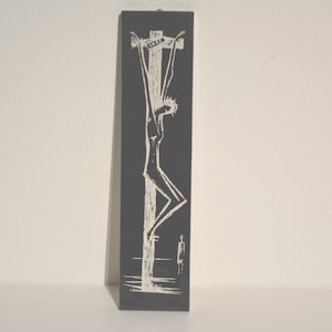 May include: A black and white illustration of a person on a cross. The illustration is on a dark gray background.