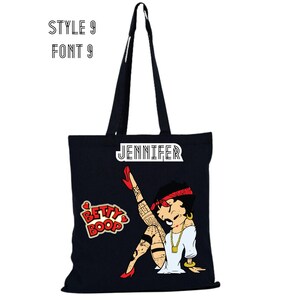 May include: Black tote bag with a white "JENNIFER" name tag and a cartoon image of Betty Boop with a red bandana, red shoes, and tattoos. The bag also has a red heart with "BETTY BOOP" written inside.