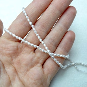 Filo di perle d'acqua dolce a forma di riso da 2 mm a 2,5 mm, perle autentiche di alta qualità, colore bianco brillante naturale, lucentezza eccellente - lunghezza 16"