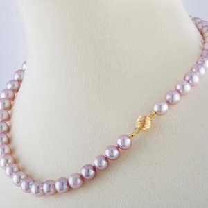 May include: A strand of lavender-colored pearls with a gold clasp. The pearls are strung on a thin silver chain.
