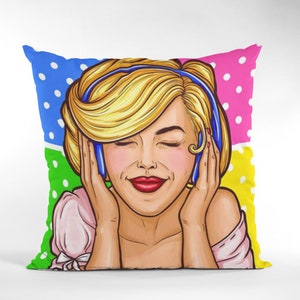 May include: Square throw pillow with a pop art style illustration of a woman with blonde hair and red lipstick. The pillow has a colorful background with polka dots in blue, green, pink, and yellow.