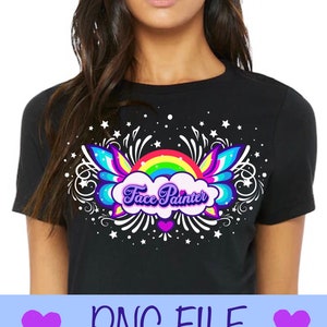 Puede incluir: Una camiseta negra con un diseño de arcoíris, nube y alas. El texto "Face Painter" está en una fuente morada y blanca.
