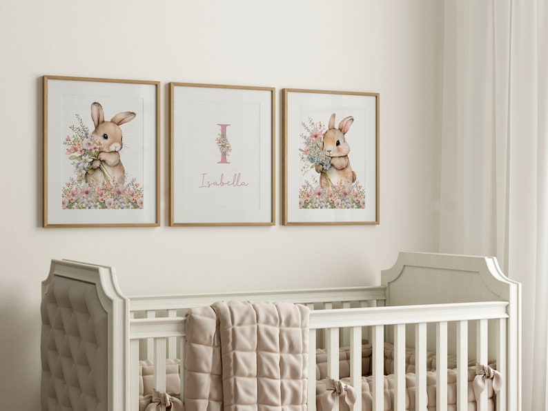 May include: Three framed prints featuring a watercolour illustration of a bunny holding flowers. The middle print has the letter "I" and the name "Isabella" written below it.