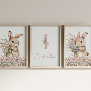 May include: Three framed prints featuring a watercolour illustration of a bunny holding flowers. The middle print has the letter I and the name Isabella.