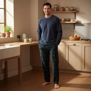 May include: A long-sleeved navy blue crew neck shirt paired with dark green and navy blue plaid pajama pants. The shirt features a solid color design with a ribbed neckline, while the pants have a classic tartan pattern with a straight leg fit.