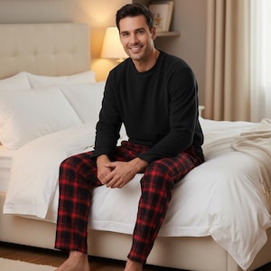 Peut inclure: Un pull à manches longues noir à col rond associé à un pantalon de pyjama à carreaux rouges et noirs. Le haut présente une couleur noire unie avec une encolure simple, tandis que le pantalon affiche un motif à carreaux classique en rouge et noir.