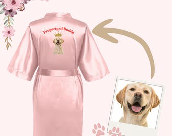 May include: Pink satin robe with the text "Property of Buddy" and a picture of a golden retriever wearing a crown on the back.