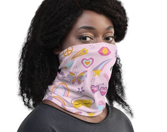 Könnte beinhalten: Eine rosa Gesichtsmaske mit einem bunten Muster aus Peace-Zeichen, Herzen, Sternen, Schmetterlingen und anderen Symbolen.
