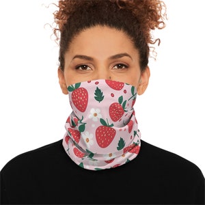 May include: A pink face mask with a repeating pattern of red strawberries, white flowers, and green leaves.