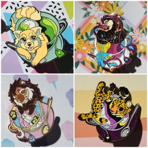 May include: Four enamel pins featuring different animal characters in teacups. The pins are colorful and detailed, with a variety of colors and patterns. The animals include a fox, a cheetah, a wolf, and a creature with a black and purple design.
