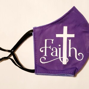 May include: Purple face mask with a white cross and the word "Faith" in a decorative font.