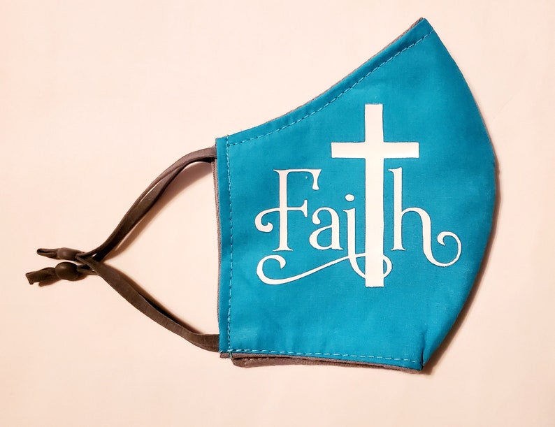 May include: A turquoise blue face mask with a white cross and the word "Faith" in a white cursive font.