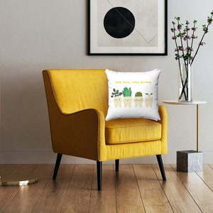 May include: A yellow armchair with a white throw pillow featuring a green plant graphic and the text "Keep smiling, keep growing".