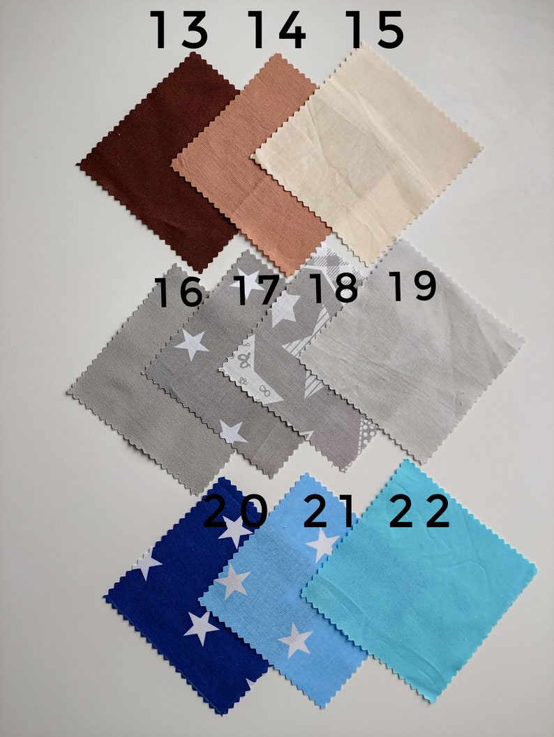 May include: A collection of 10 fabric swatches in various colors and patterns. The swatches are numbered 13 through 22. The swatches include brown, peach, beige, gray, blue, and light blue. Some swatches have a white star pattern.