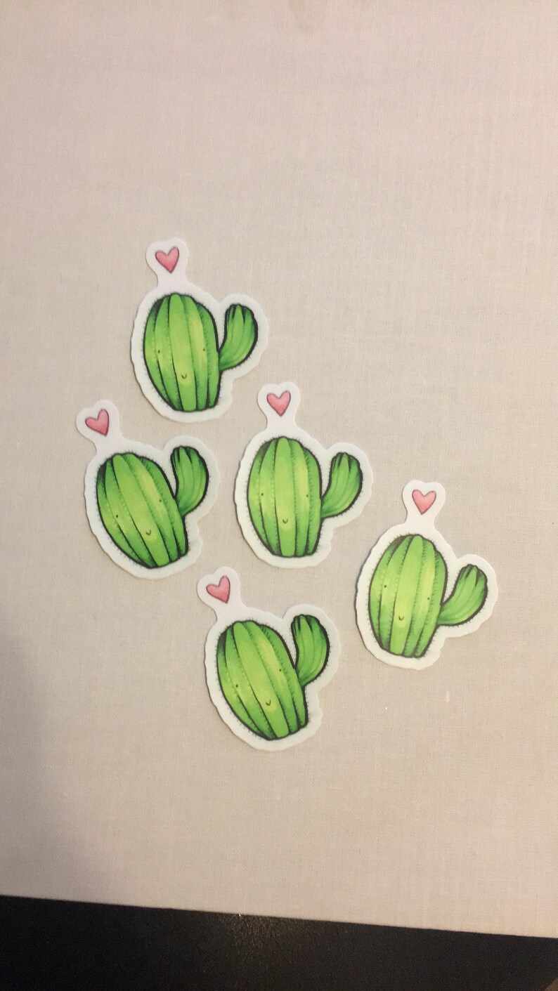 May include: Five green cactus stickers with pink hearts on top. Each cactus has a smiling face and a single arm.
