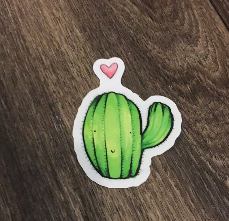 May include: A green cactus with a pink heart on top. The cactus has a smiling face and a single arm.
