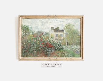 May include: A framed painting of a garden scene with a white house in the background. The garden is filled with colorful flowers and greenery. The painting is in a light wood frame.