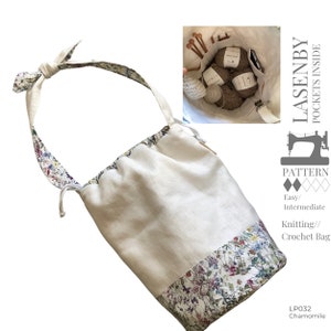 May include: A white linen drawstring bag with a floral print on the bottom half. The bag has a long strap and is designed to hold knitting needles and yarn. The bag is labeled "Lasenby Pockets Inside" and "LP032 Chamomile".
