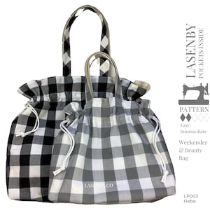 Può includere: Due borse tote a quadri bianchi e neri con coulisse bianche. La borsa più grande ha un manico a quadri bianchi e neri. La borsa più piccola ha un manico bianco. Le borse sono etichettate "Lasenby Co."