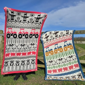 May include: Two knitted blankets with farm-themed patterns. One has a red border and features tractors, sheep, and a scarecrow design. The other has a blue border and features tractors, sheep, and a scarecrow design.