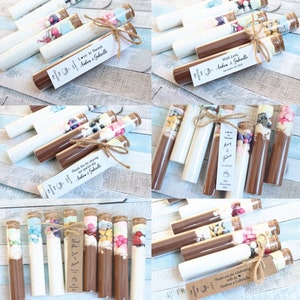 May include: Assortment of small glass test tubes filled with colorful candies, marshmallows, and chocolate powder. Each tube is tied with twine and a personalized tag with the text "Love is Sweet" and the names "Andrea & Gabrielle".