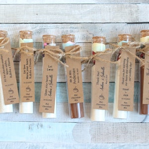 May include: Ten small glass test tubes filled with hot chocolate mix and tied with twine. Each tube has a brown paper tag with a personalized message, such as "Let love warm your heart" and "Thank you for warming our hearts".