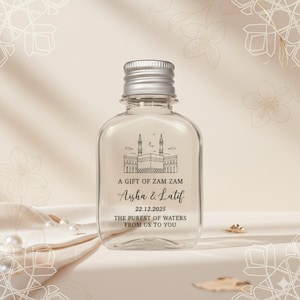 Peut inclure: Bouteille en verre transparent avec un bouchon argenté, avec du texte et une illustration d'un bâtiment avec des minarets. Le texte se lit "A GIFT OF ZAM ZAM Aisha & Latif 22.12.2025 THE PUREST OF WATERS FROM US TO YOU."