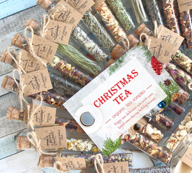 May include: A collection of tea samples in glass tubes with cork stoppers, arranged in a circular pattern. Each tube is labeled with a different tea type. A card in the center reads "Christmas Tea" with a cup of coffee and holiday decorations.