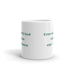 May include: A white ceramic coffee mug with green text. The text includes the words "refilled", "Energy", and phone numbers. The mug is cylindrical and sits on a white surface.