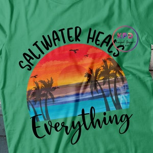 K&ouml;nnte beinhalten: Gr&uuml;nes T-Shirt mit einem Sonnenuntergangs-Motiv und dem Text "Salzwasser heilt alles".