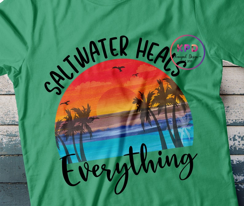 K&ouml;nnte beinhalten: Gr&uuml;nes T-Shirt mit einem Sonnenuntergangs-Motiv und dem Text "Salzwasser heilt alles".
