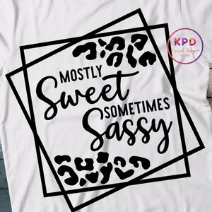 Puede incluir: Dise&ntilde;o gr&aacute;fico en blanco y negro con un patr&oacute;n de estampado de leopardo. El texto dice "Mostly Sweet Sometimes Sassy" dentro de un marco cuadrado doble negro.