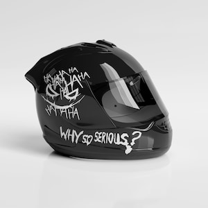 May include: Glossy black motorcycle helmet with a tinted visor. The helmet features a white graphic of a grinning face with the words "HA HA HA" and "WHY SO SERIOUS?" in a graffiti-style font.